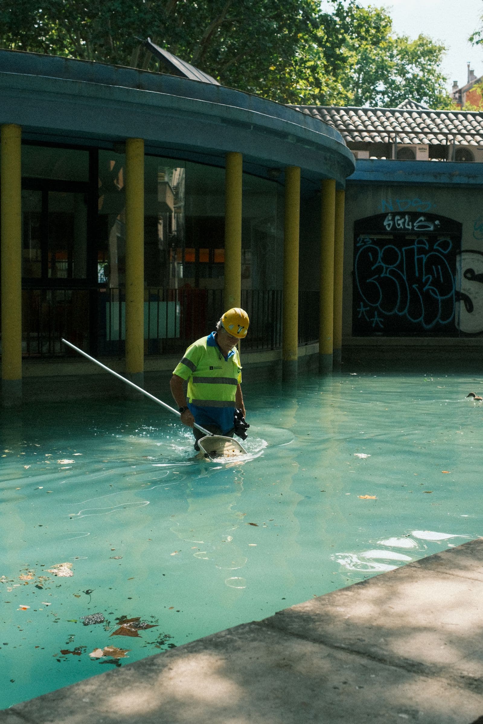 A pool technician cleaning a pool.