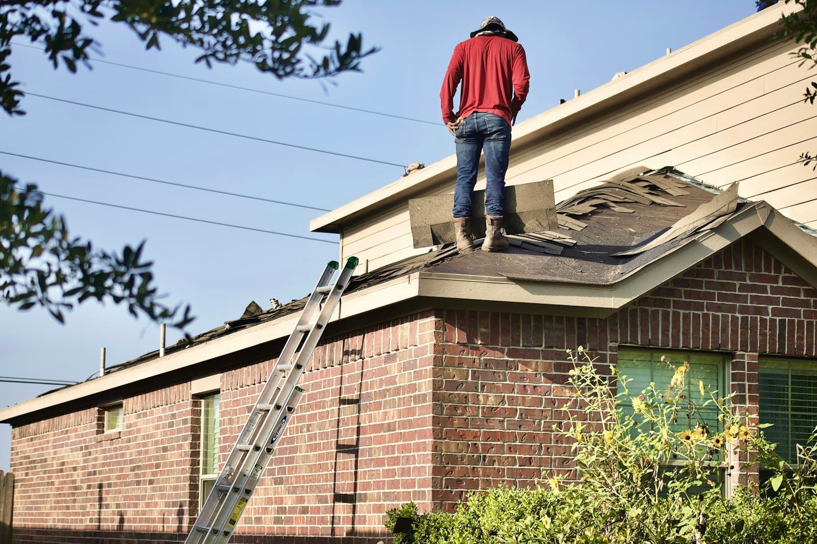 A roofer standing on a house roof.