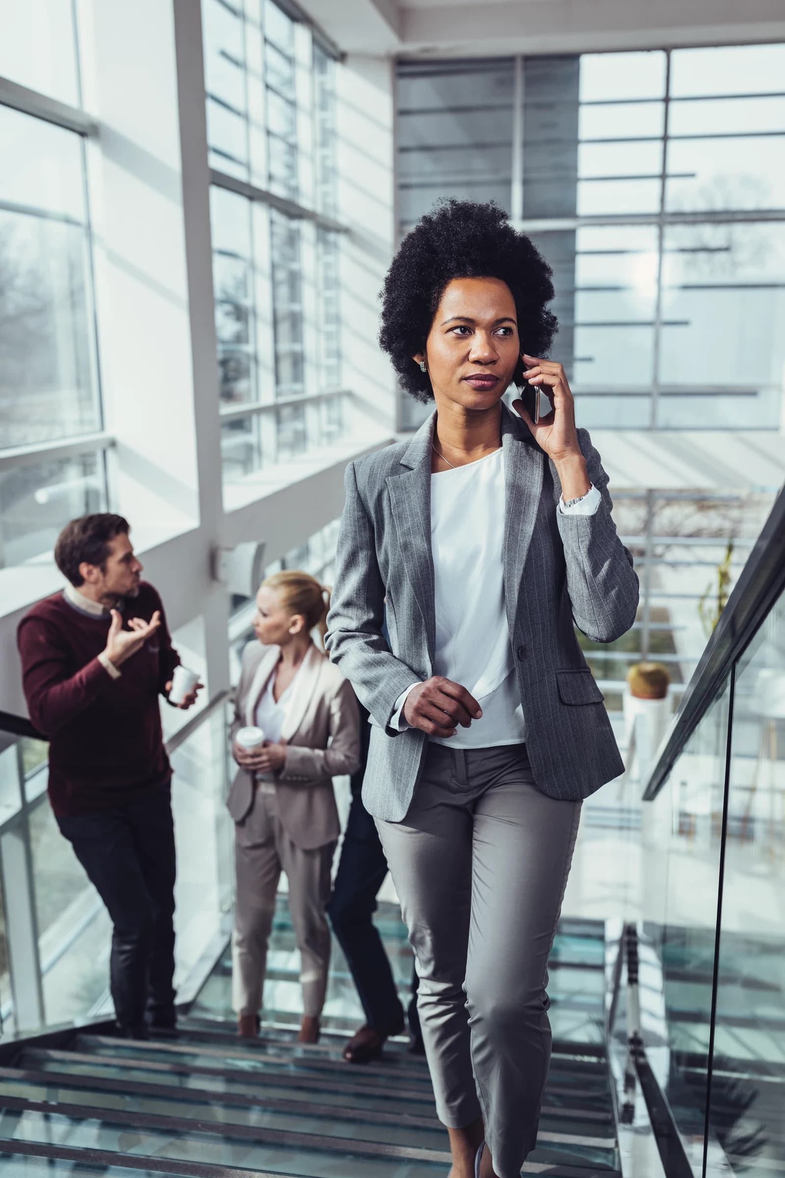A businesswoman talking on the phone on a staircase