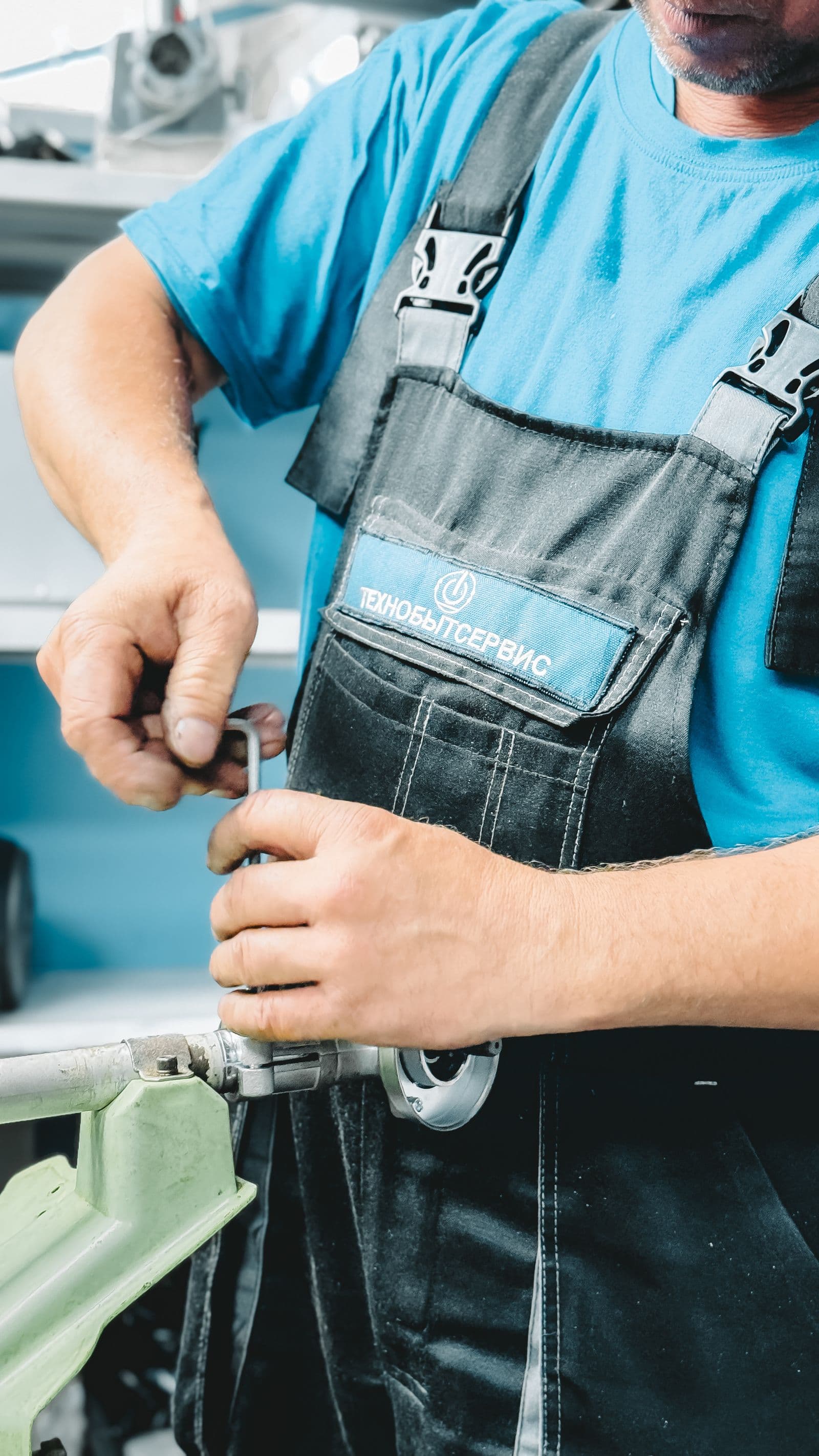 Plumber working under a sink with wrench in tight crawlspace