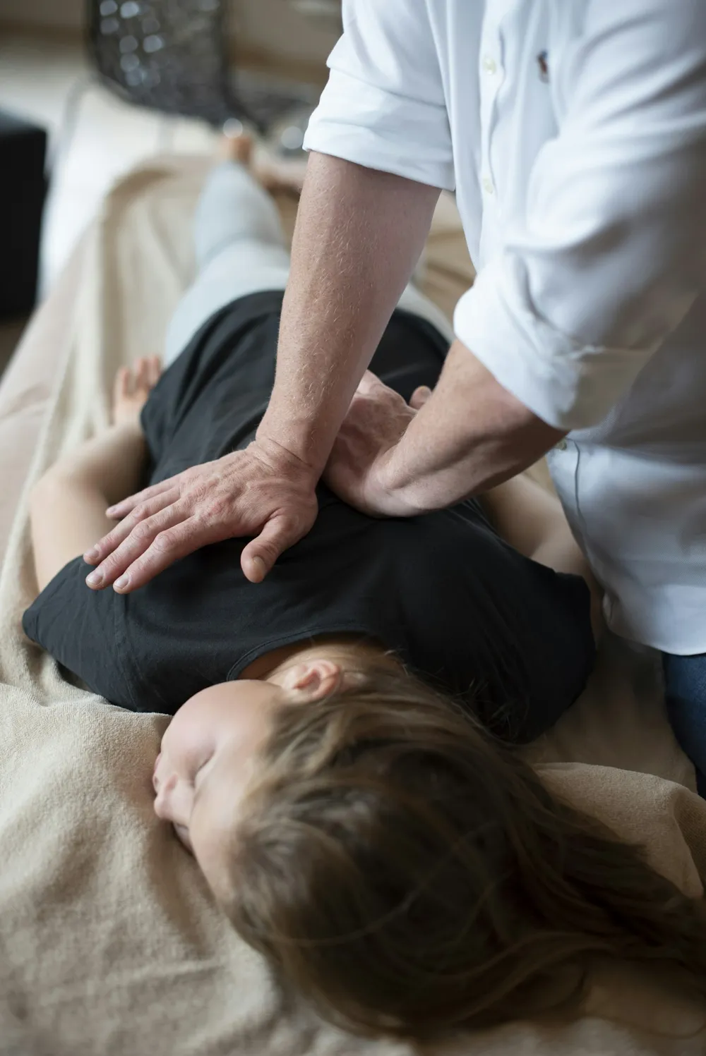 A chiropractor's hands on a patient's back